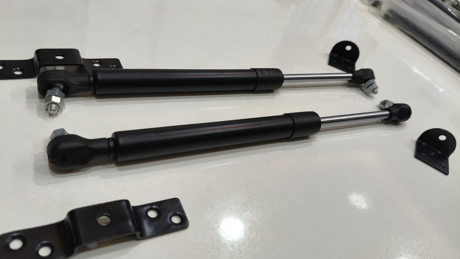 Gas springs with mounting brackets, ready for dispatch